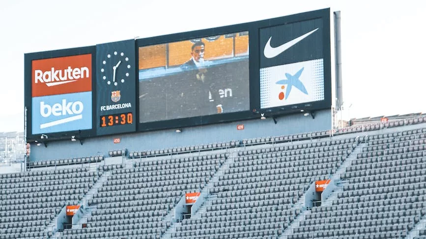 stadium bleachers with a wide screen monitor and a big clock