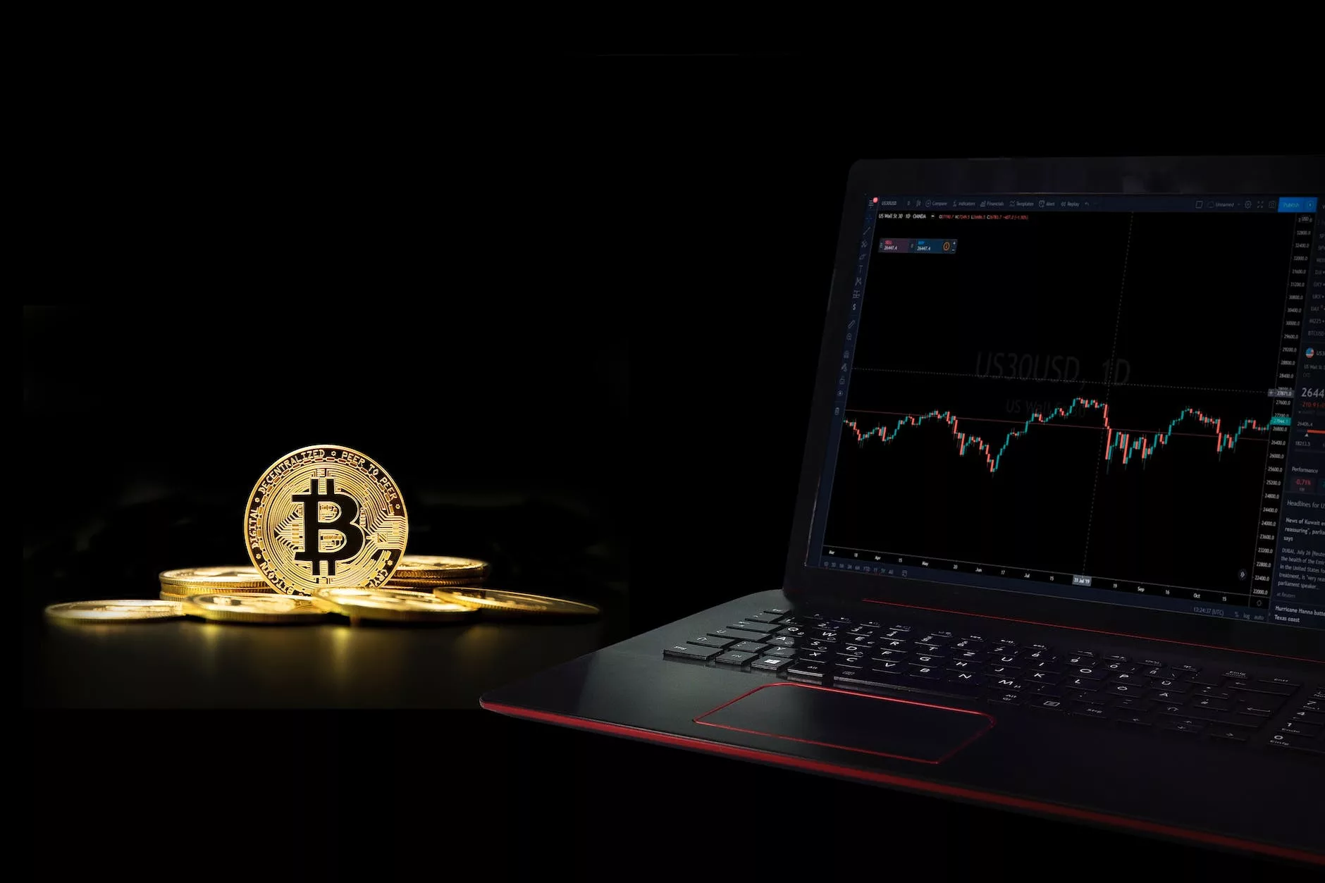 a laptop displaying a graph beside a commemorative coin